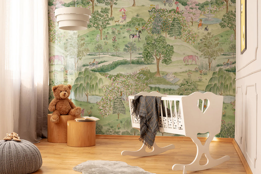 A warmly lit room with light wooden floors, a unique white rocking chair, and a large teddy bear on a stool. The room is adorned with a A Stroll in the Park Mural Wallpaper, creating a cozy atmosphere.