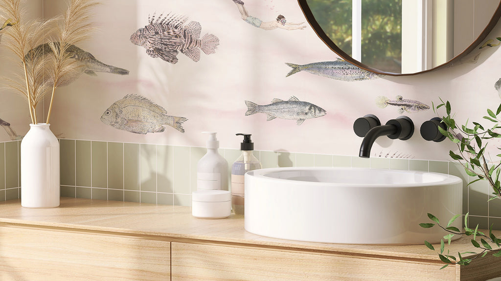 Classic Fish, Pattern Wallpaper in Pink enhances a modern bathroom with a white ceramic sink on a wooden countertop, black fixtures, green tiles, and a vase with dried pampas grass.