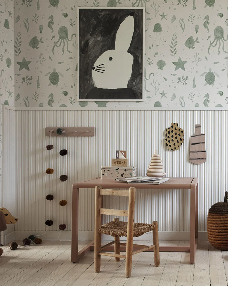 Corals and Friends, Wallpaper in Dark Green Featured on a wall of a kid’s study room with a wooden study table, and toys scattered around