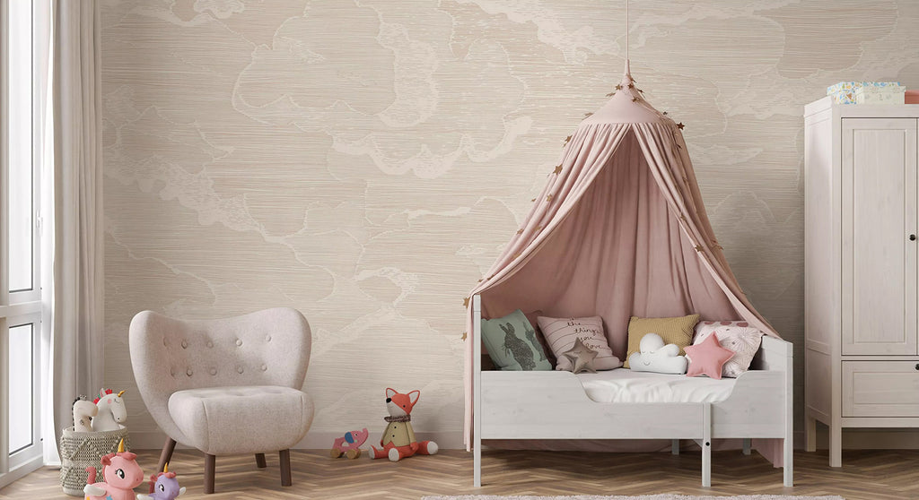 Illustrated Clouds, Mural Wallpaper in Grey adorns the room, setting a serene backdrop for a white crib with a cozy shelter of a pink tent, and a white chair. These pieces of furniture are surrounded by plush toys