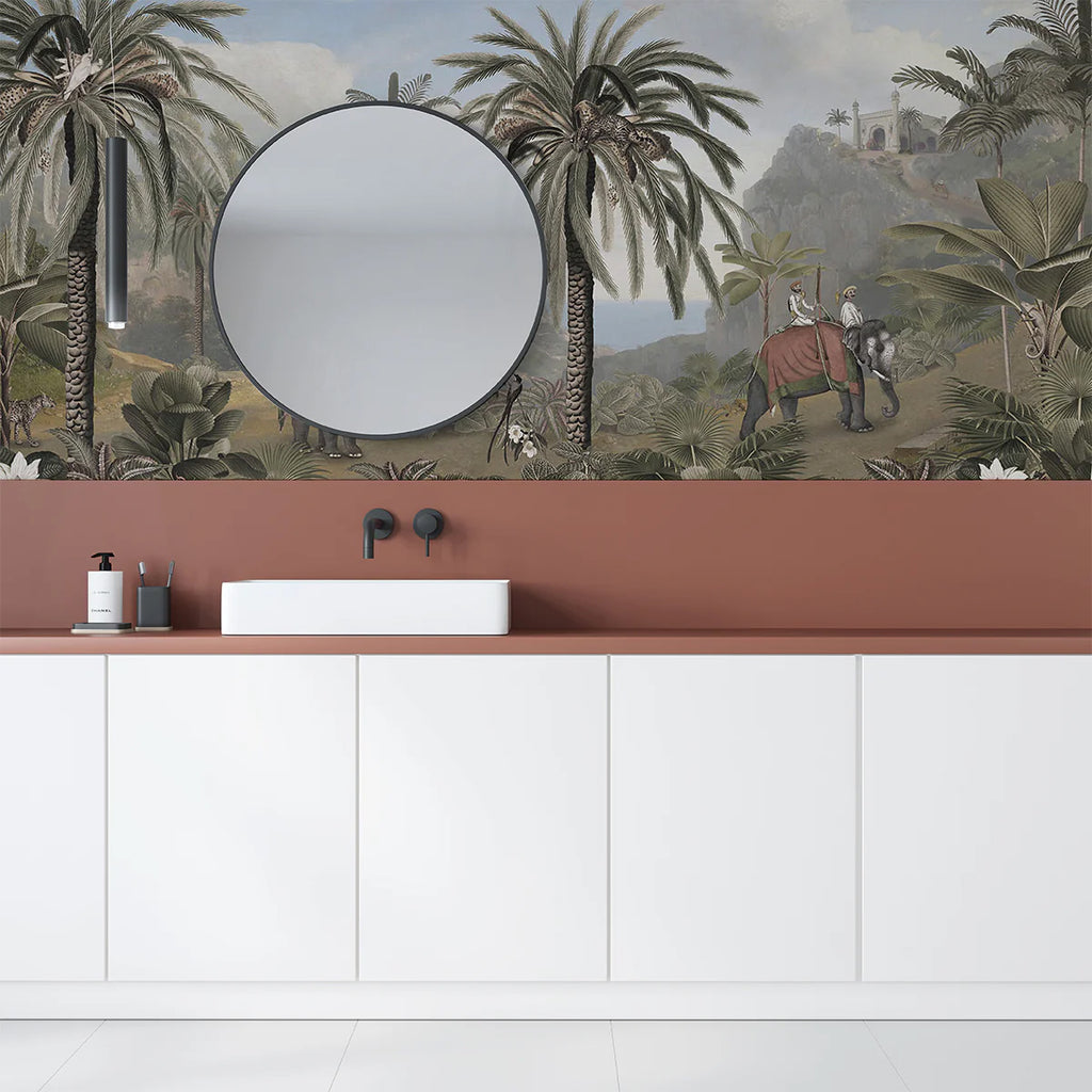 A modern bathroom adorned with a Majestic Elephant, Animal Mural Wallpaper. The room features a sleek white vanity unit, a terracotta backsplash, a round mirror, and minimalist black fixtures against a vintage looking wallpaper featuring Majestic elephant in the old world.