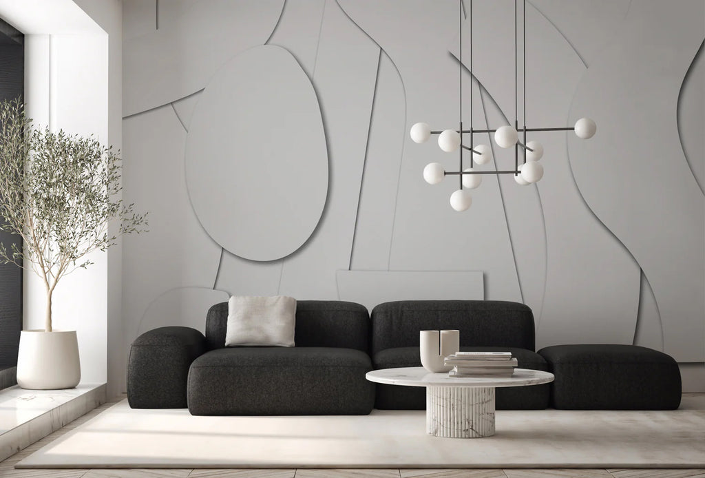 Modern minimalist living room with a dark gray sectional sofa, round coffee table, and a unique branching chandelier, all complemented by the Offcut Shapes, Geometric Wallpaper.