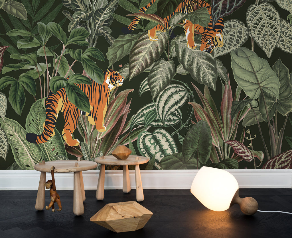 Playful Tiger, Pattern Wallpaper in forest green colourway as seen on a wall of a rooms with two wooden stools and lamp on the ground