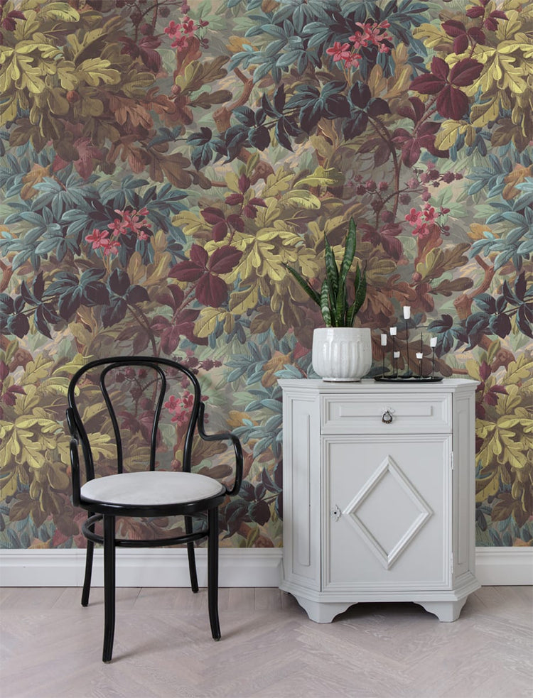 Raspeys, Floral Pattern Wallpaper featured on a wall of a room with a chair and a white side cabinet that has a plant on it. 