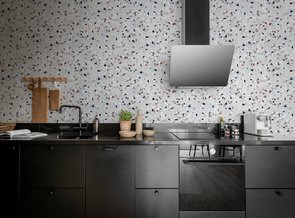 Terrazzo Kern, Faux Texture Wallpaper featured on the wall of a kitchen area, with black countertops and fixtures
