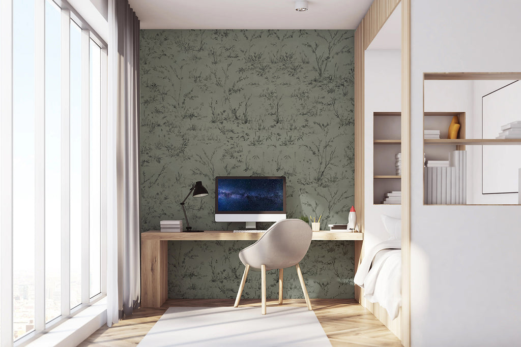 Trisha Floral Pattern Wallpaper, in a refreshing green tone, is displayed on a wall of a room. The room is furnished with a computer table that holds a desktop set, positioned next to a white bed.