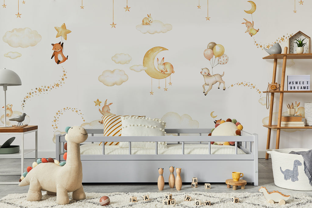 A child’s room with a whimsical Twilight Safari Wallpaper in White. Features include a toddler bed, a toy-filled shelf, a lamp, and a plush dinosaur on a white rug.