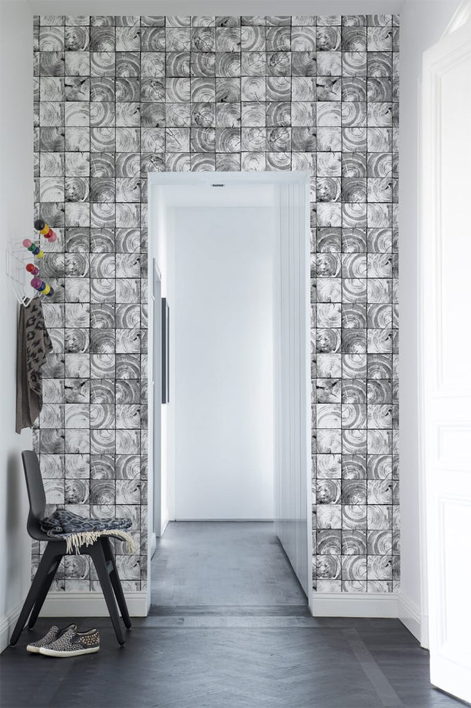 Reflection Patterned Wallpaper in black featured on a wall of a hallway with a chair along the way