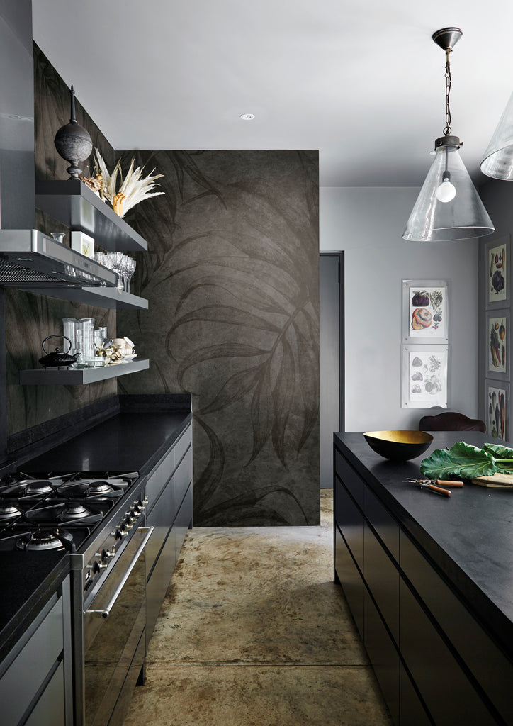 The Dark Grey Terry Leaf Wallpaper elegantly decorates a wall in the kitchen area, adding a touch of sophistication to the space.