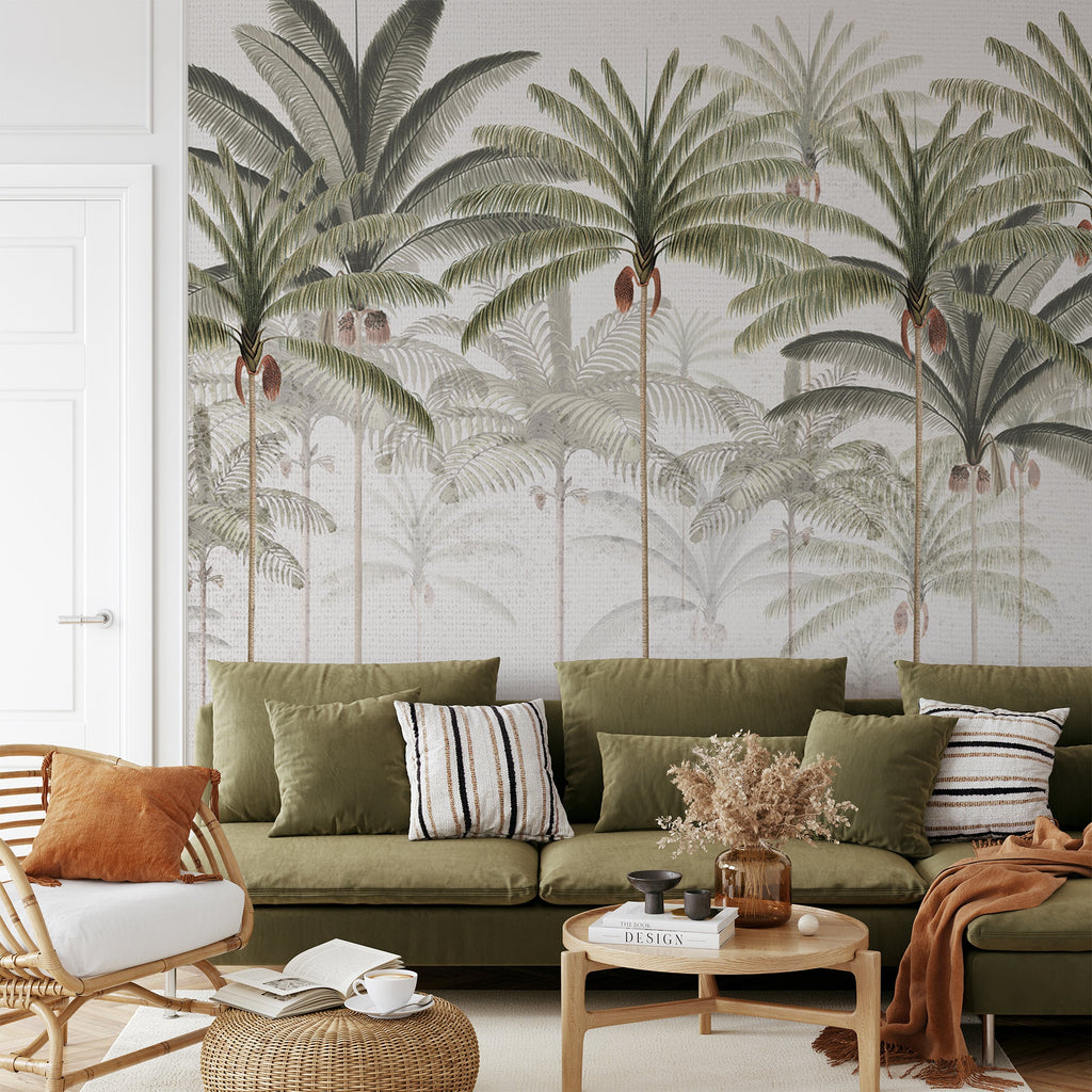 Within a living area furnished with sofa sets featuring green cushions, a white Rainforest Vintage, Mural Wallpaper adds a touch of elegance to one of the walls.