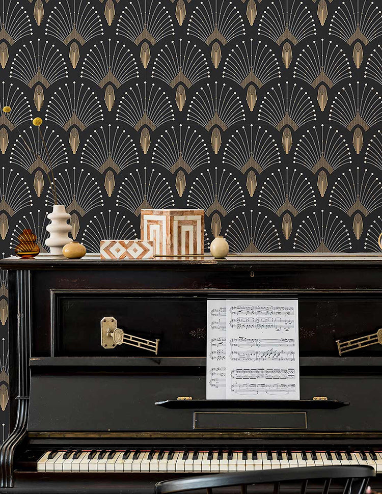 An elegant room featuring a polished black piano, adorned with eclectic décor. The piano, ready for performance, holds a sheet of music. The room’s charm is accentuated by the 1920s Fan, Geometric Wallpaper in Black.