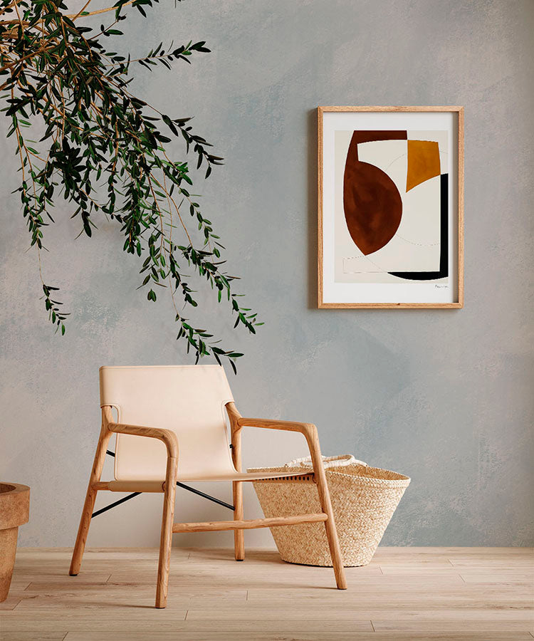 A contemporary room adorned with Addison Chalk, Ombre Wallpaper in Blue, sets a tranquil mood. A modern beige armchair, a woven basket, and a framed abstract artwork add elegance. The room’s minimalist design, complemented by a touch of greenery, exudes a serene and inviting atmosphere.
