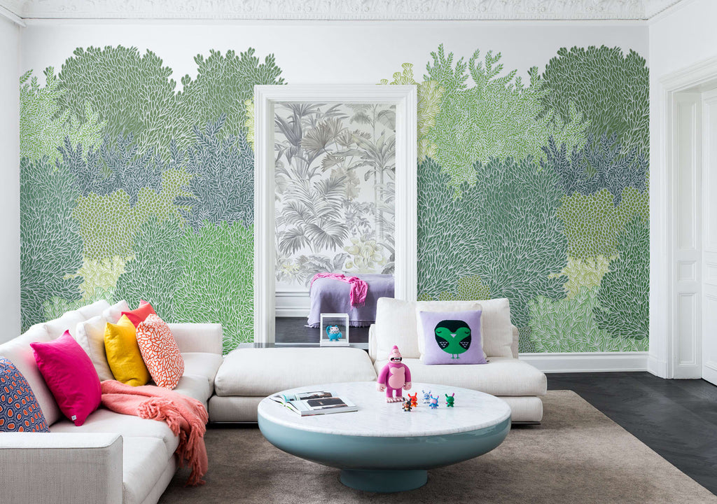 Alice Garden, Mural Wallpaper in green featured in a living area with white cushions, multicolored pillows, and a round table