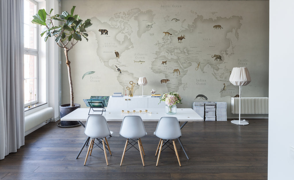 Animal Atlas, World Map Mural Wallpaper in living room with dining table and a tall plant