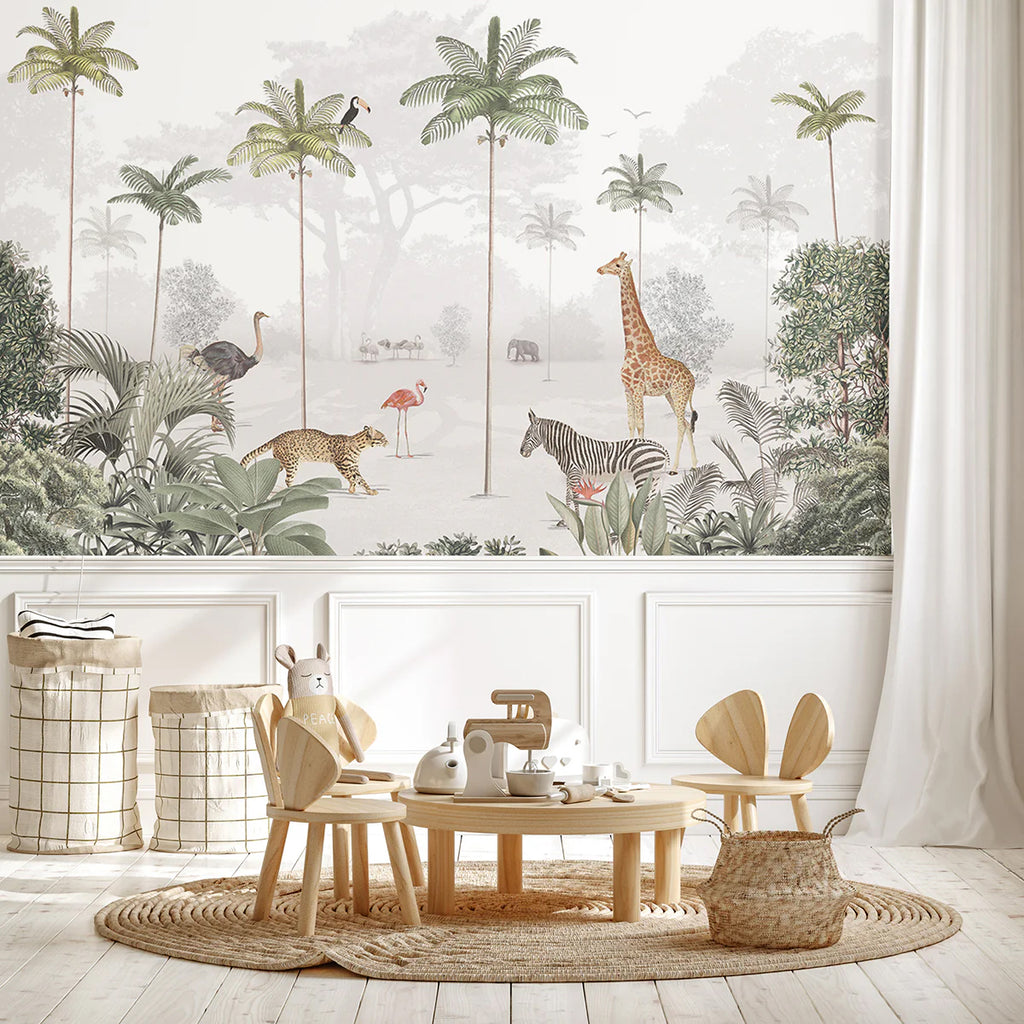 A cozy room with wooden flooring, a round table with chairs, and a shelf filled with toys. The wall features the Animal Paradise, Mural Wallpaper in Light Green depicting a serene jungle scene