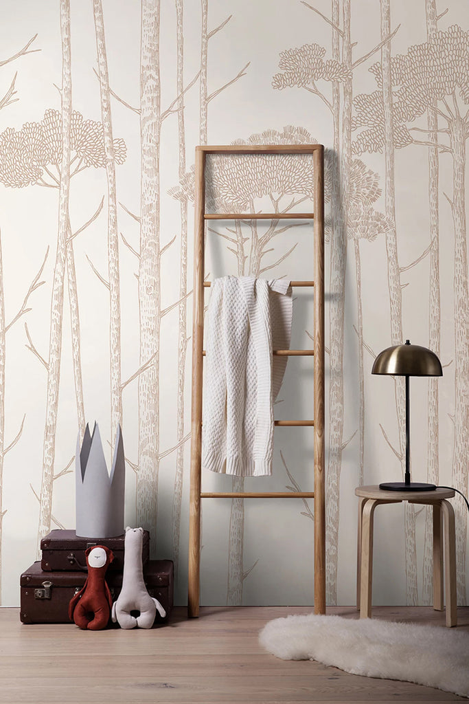 Ara's Birch Trees, Mural Wallpaper in Nude featured in a room that is adorned with a wooden ladder, a towel, a lamp atop a wooden stool, and two stacked brown briefcases beside the ladder.