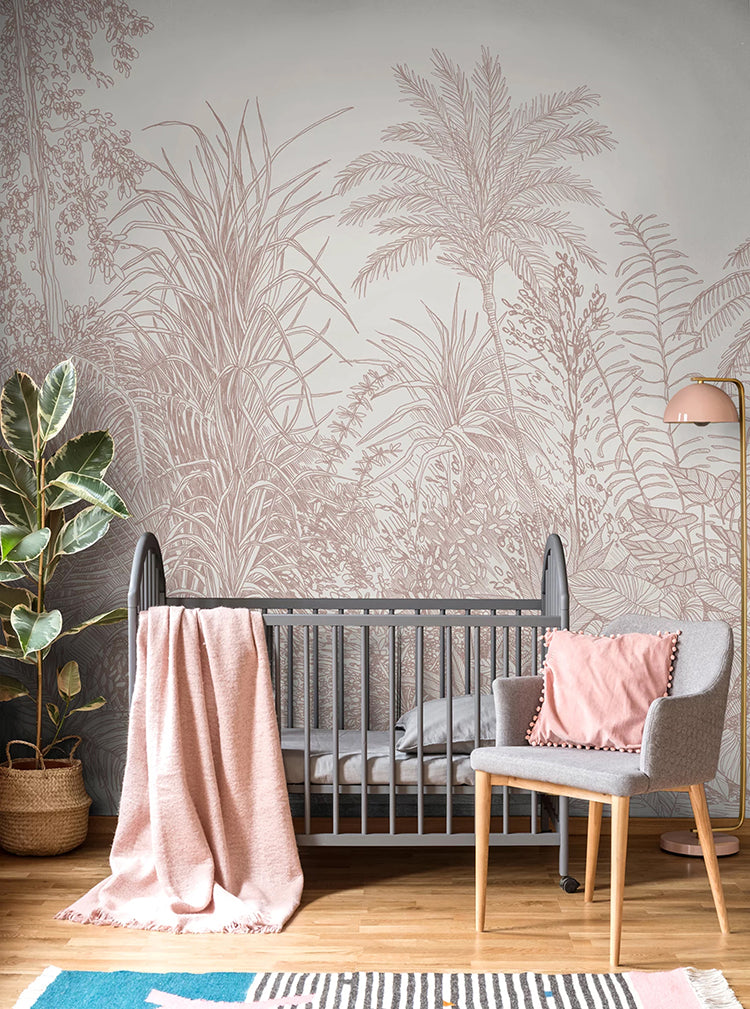 Ara's Jungle, Tropical Mural Wallpaper in Nude featured in a child’s nursery room with a grey crib and pink blanket and a grey chair with pink pillow