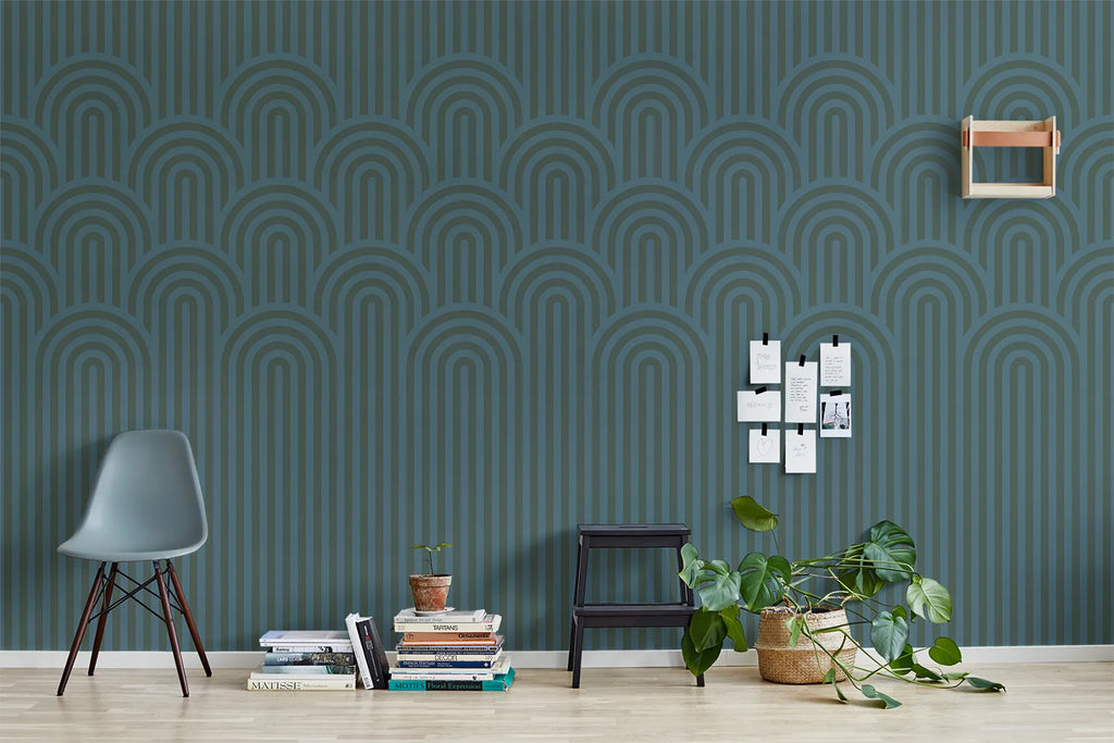 Arch Hills, Geometric Wallpaper in Emerald Green featured on a wall of room with wood flooring with green chair and stacked books