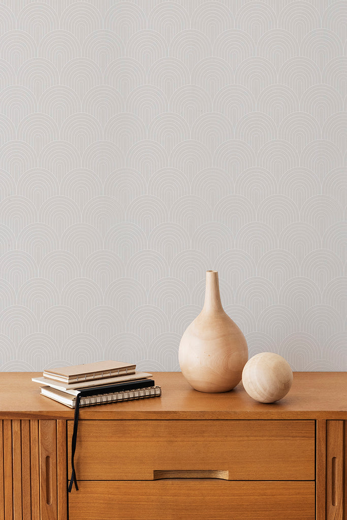 A serene room featuring an Arch Passage, Pattern Wallpaper. A wooden sideboard houses decor items, including a tall beige vase and a small stack of hardcover books. The room’s earthy color palette evokes a sense of calm and minimalism.