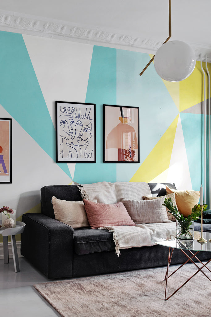 Big Summer Diamond, Mural Wallpaper featured on a wall of a living area with a round glass table, black sofa, and multicolored pillows, a round glass table 