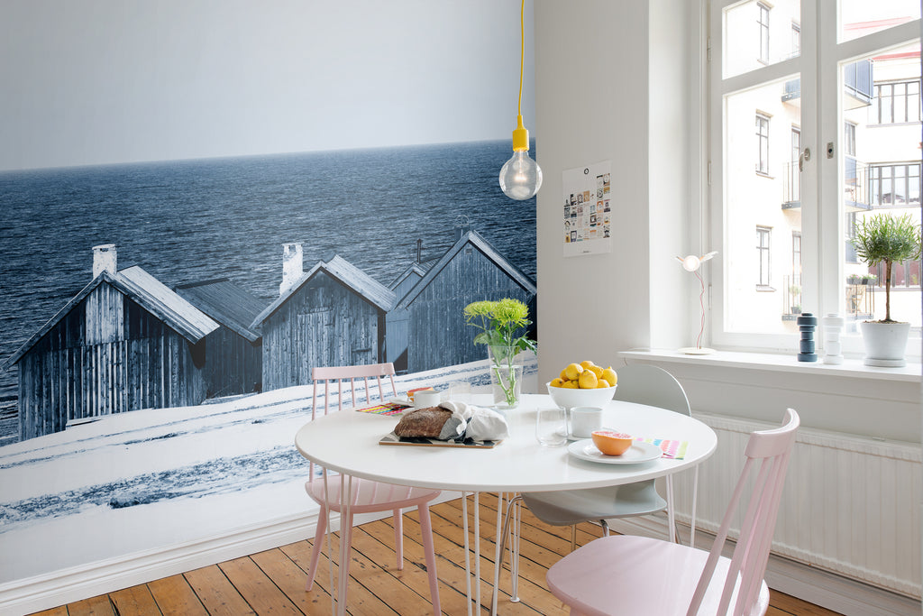 Boathouse Blues, Landscape Mural Wallpaper, featured on wall of a cozy dining area with round dining table and pink chairs 