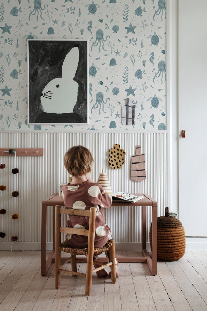 Corals and Friends, Wallpaper in Blue Featured on a wall of a kid’s study room with a wooden study table, and wooden flooring