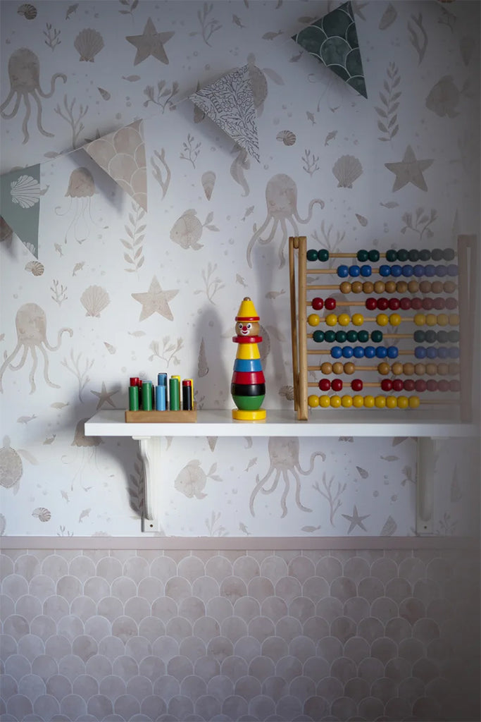 Corals and Friends, Wallpaper in Nude Featured on a wall of a kid’s room with a shelf with toys on top of it.
