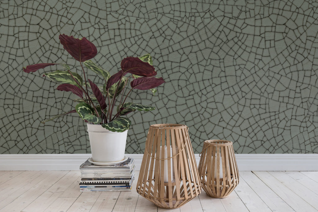 Crackle, Pattern Wallpaper in sage in a room with a plant pot on stacked books and wooden candle container