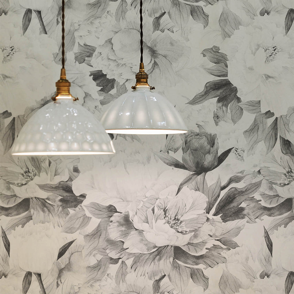 Two elegant pendant lights casting a soft glow on the ‘Delicate Grey Peonies, Floral Pattern Wallpaper’. The wallpaper showcases intricate peony illustrations in soft grey tones, adding a touch of elegance.