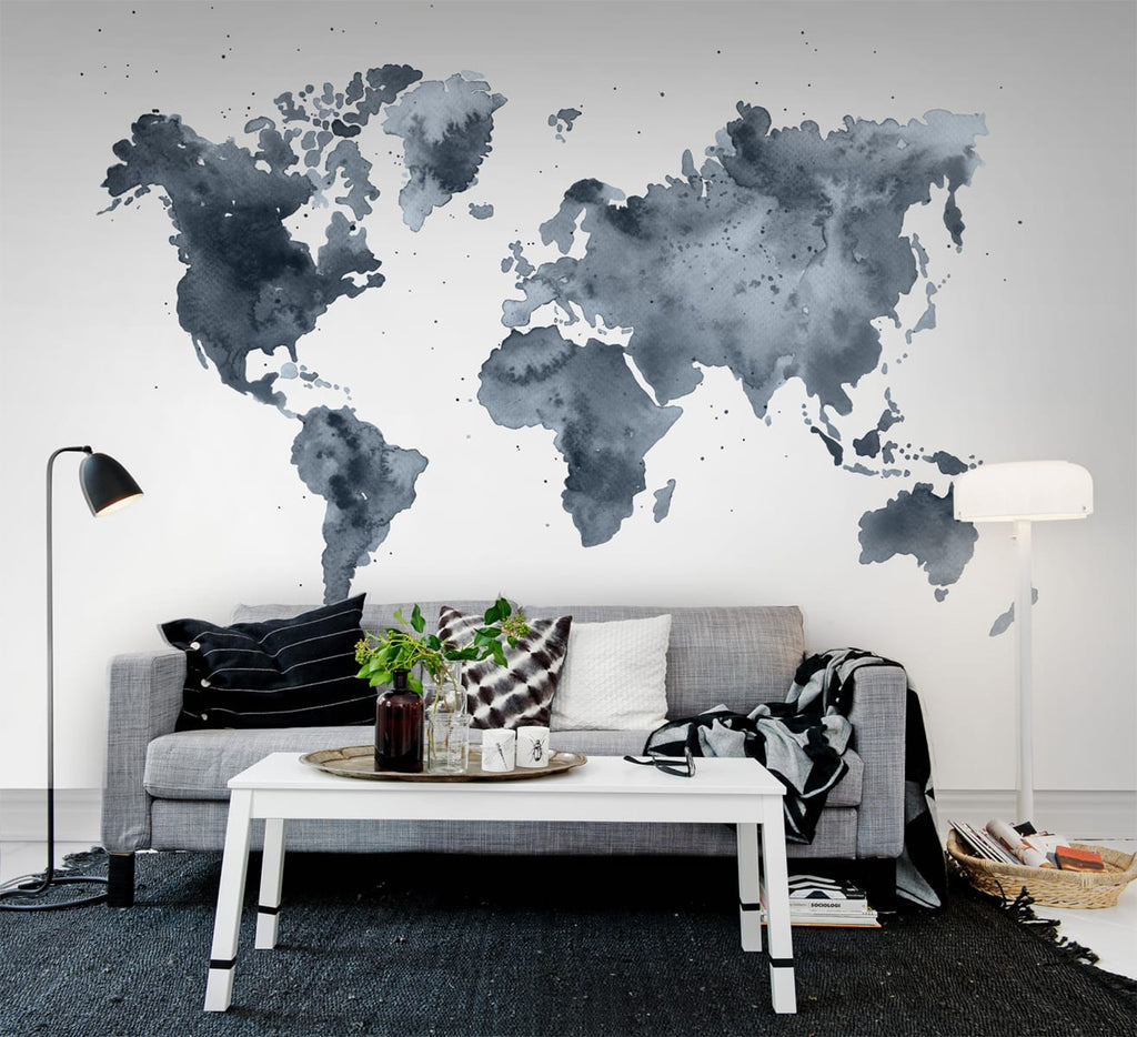 Dusky World Map, Mural Wallpaper featured on a wall of a living area with grey sofa that has multi designed pillows and dark grey floor mat