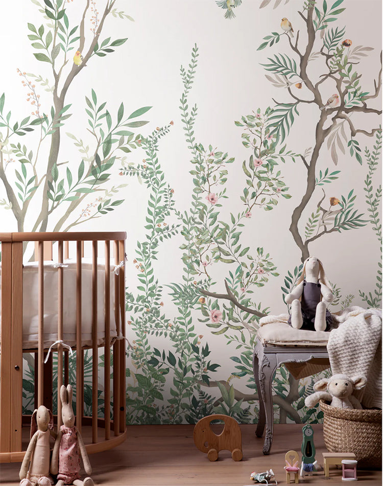 Fairy Garden Mural Wallpaper adorns a wall in a child’s nursery, with plush and wooden toys scattered on the floor.