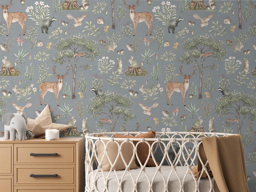 Fantastic Forest, Pattern Wallpaper in blue colourway. The nursery room includes a wooden dresser with an elephant plush toy, and a crib with a brown blanket.
