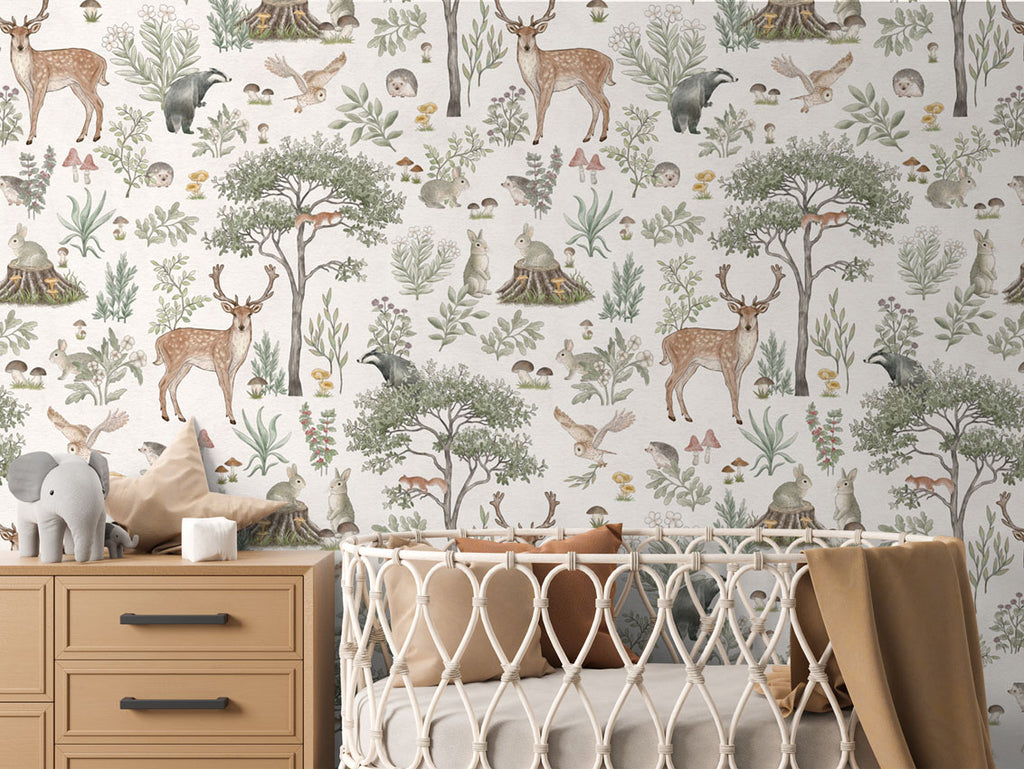 Fantastic Forest, Pattern Wallpaper in White colourway. The nursery room includes a wooden dresser with an elephant plush toy, and a crib with a brown blanket.