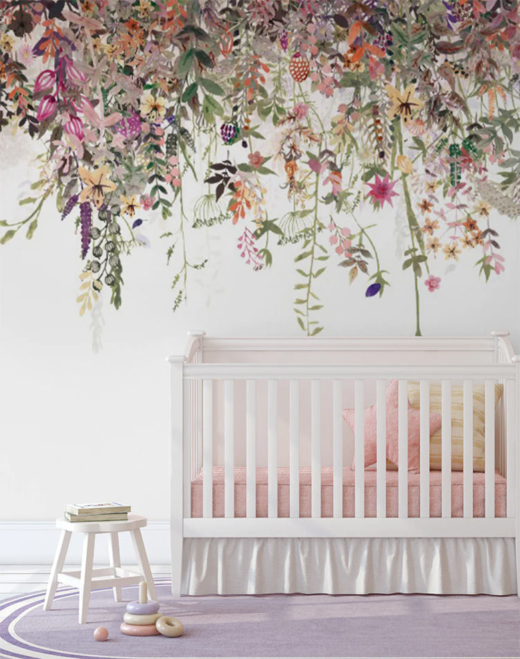 Floral Magic Mural Wallpaper enhances a child’s nursery room, complemented by a white crib and stool.
