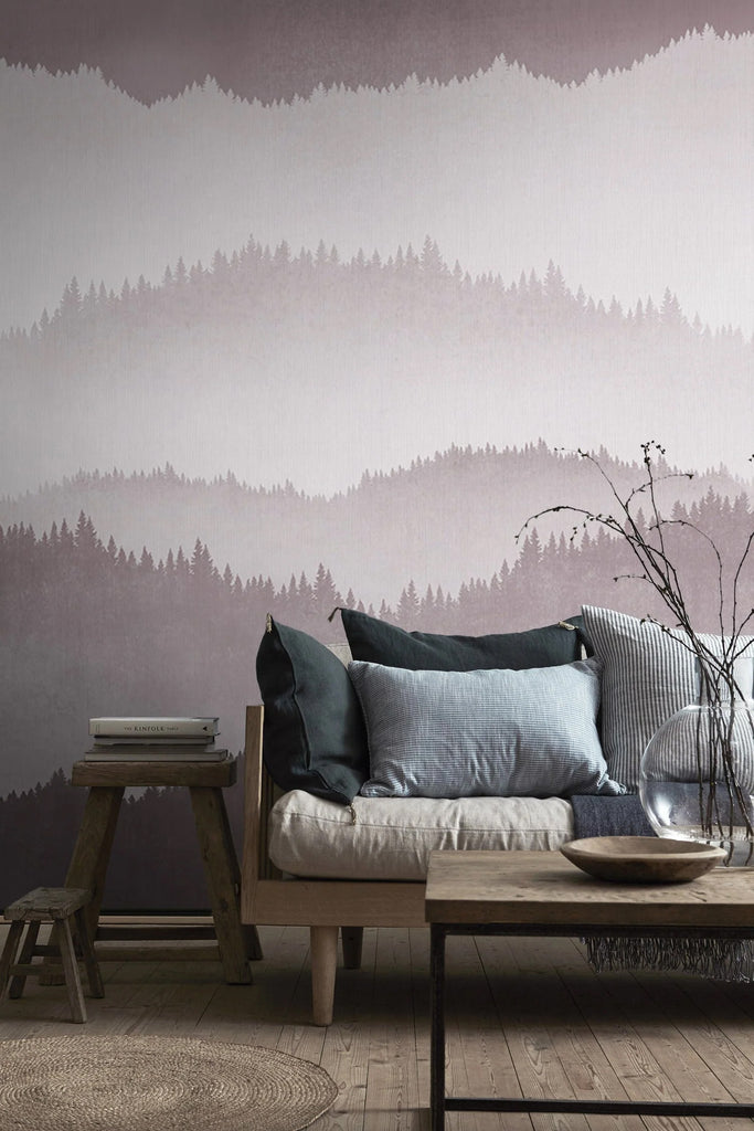 Forest Landscape, Ombre Mural Wallpaper in Crimson featured in a wall of a living area with wooden furnitures and flooring, with an assortment of pillows on top of a cushion. 