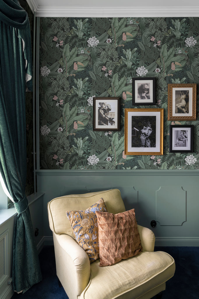 Furada Floral & Toucan, Pattern Wallpaper in dark green colourway in a living room and wall panels and yellow arm chair on the side 