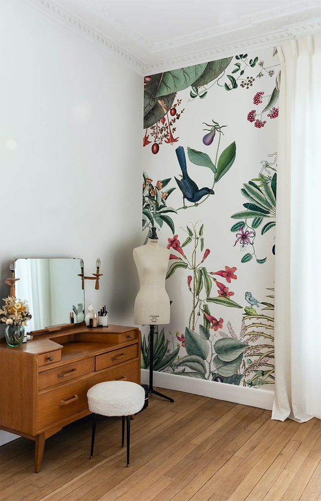 A room with a Garden Party, Mural Wallpaper showcasing a vibrant display of flora and fauna. The wallpaper complements the wooden furniture and white decor, creating a lively and stylish space.
