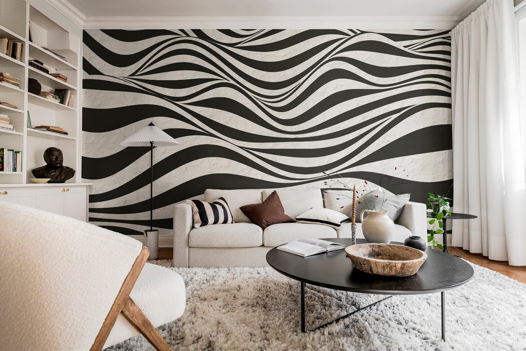 Graphic Hills, Wallpaper in black featured on the wall of a cozy living area with coffee table and decorated shelf