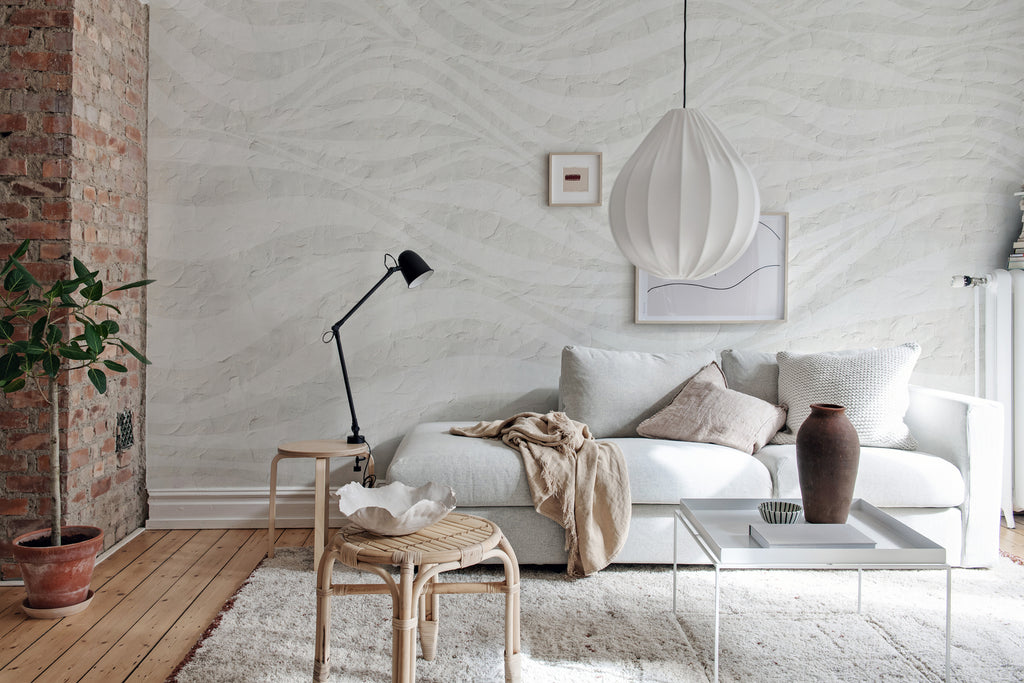 Graphic Hills, Wallpaper in white featured on the wall of a cozy living area with rattan and neutral color furniture