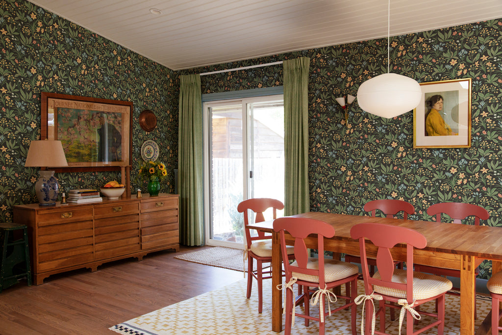 Huset i Solen, Floral Pattern Wallpaper in Black colourway, adoring the wall of a dining area with wooden furnitures and floorings
