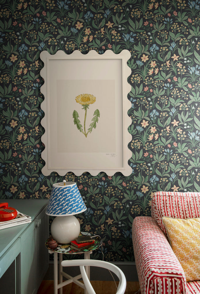 Huset i Solen, Floral Pattern Wallpaper in Black adorning the wall with a picture frame, featured in a living area with a red  and white sofa, and a side table with a lamp.