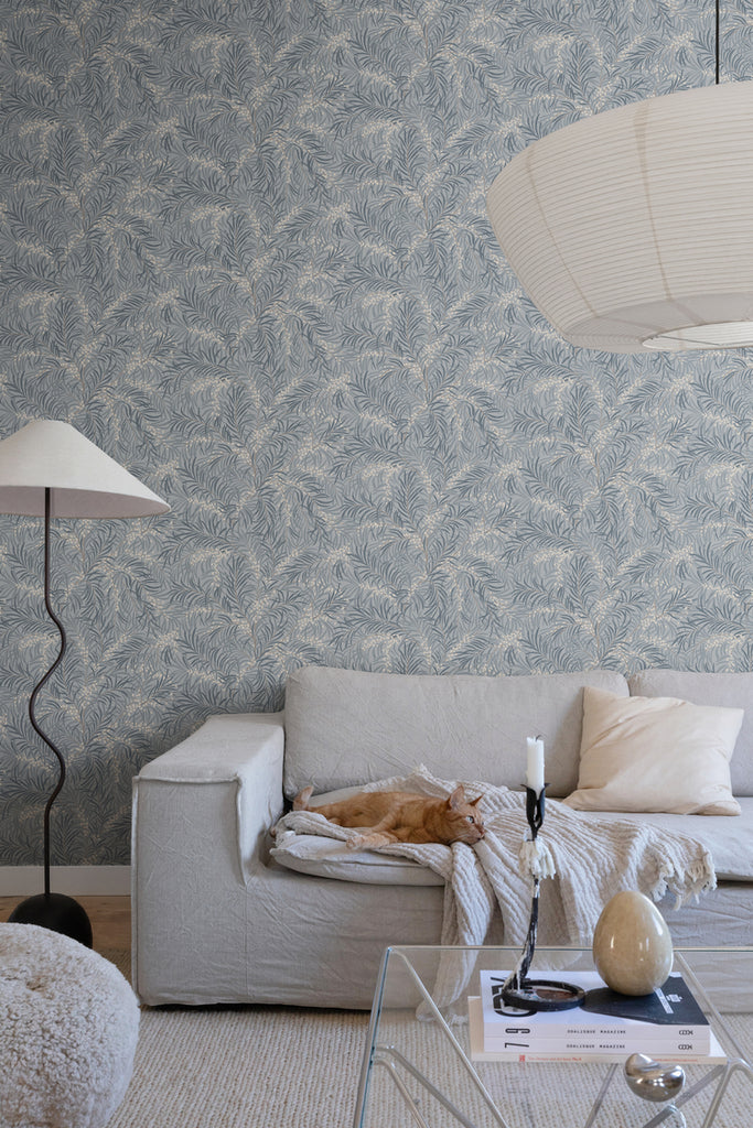 Idun, Nature Pattern Wallpaper in light blue featured on a wall of a bedroom with a bed with a patterned sheets and pillows. 