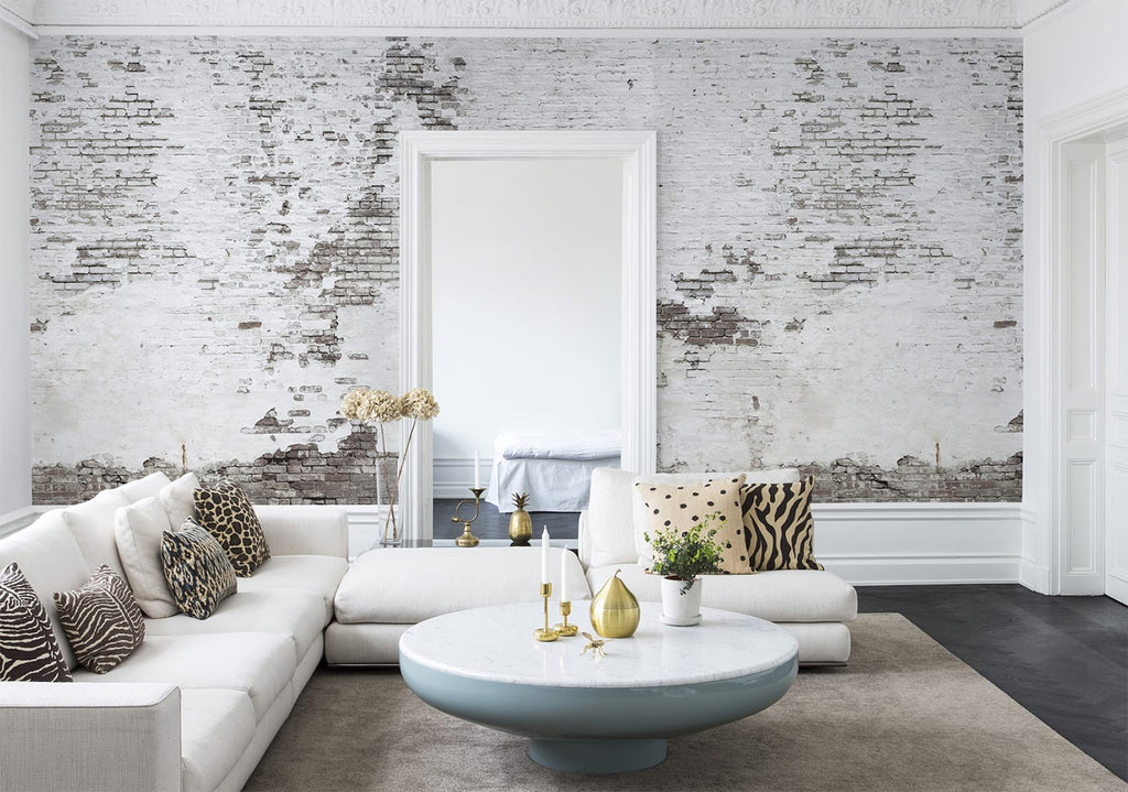 Industrial Ivory, Mural Wallpaper featured on a wall of a living area with white sofa and multiple pillows with animal skin pattern, it has a marble round table and a fabric floormat