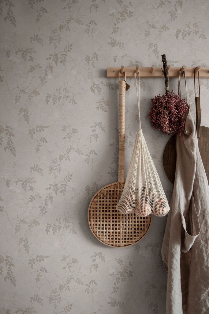 Irene, Floral Pattern Wallpaper in Grey featured on a wall with several groceries and clothes hanging on it
