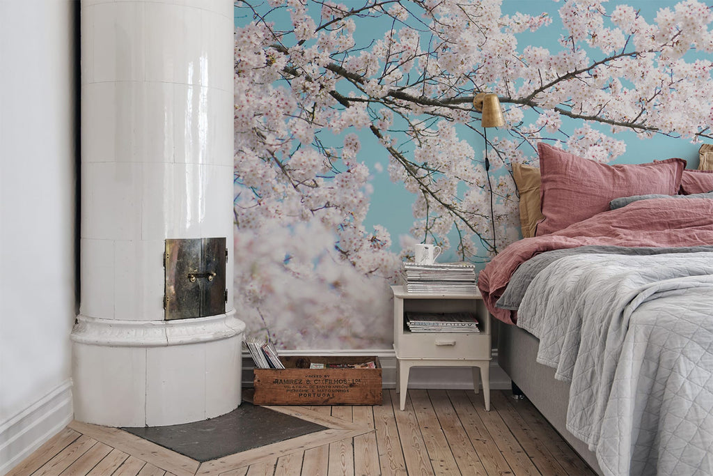 Japanese Cherry Tree, Mural Wallpaper featured in a bedroom with a bed with grey sheets and pink pillows with white side table and wood flooring