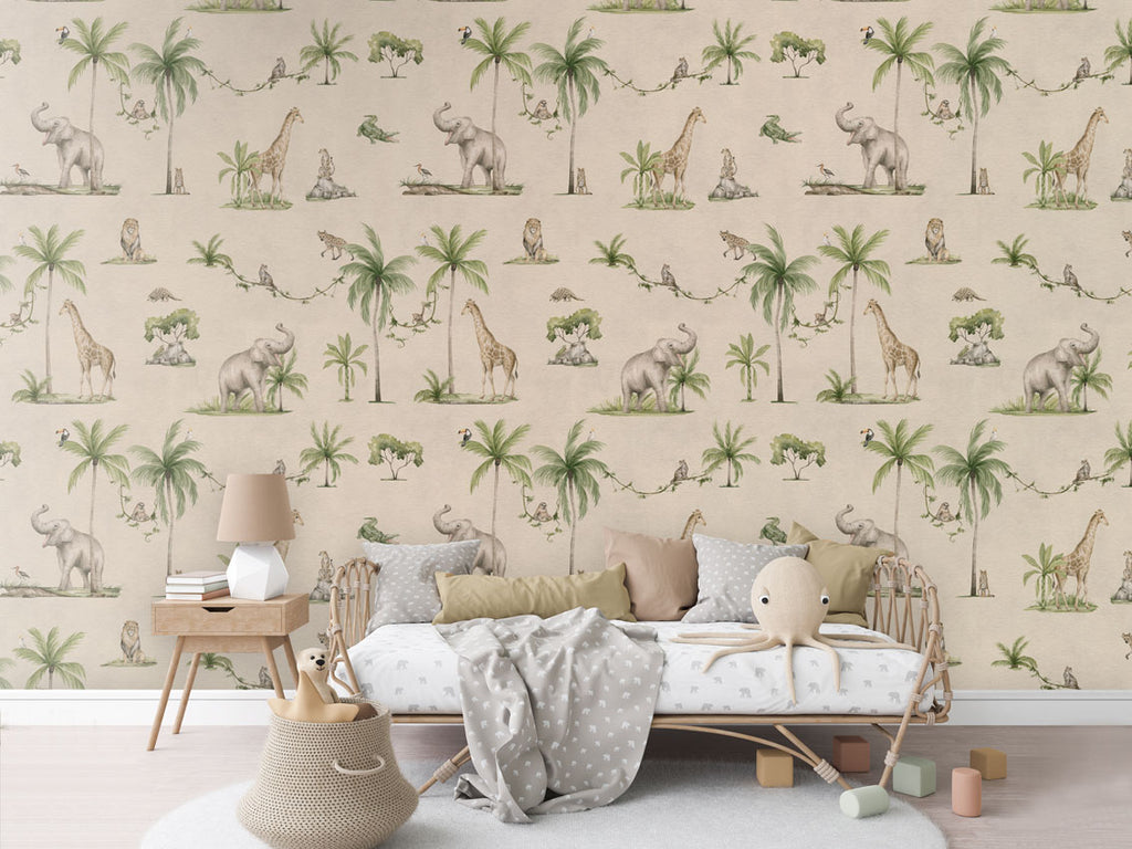 Joyful Jungle Pattern Wallpaper in a vibrant green and sand colourway. The room features a cozy reading nook with a comfy armchair, a small wooden bookshelf filled with children's books, and a soft, patterned rug. The wallpaper showcases lively jungle animals like elephants, giraffes, and parrots amidst lush foliage, creating a playful and inviting atmosphere.