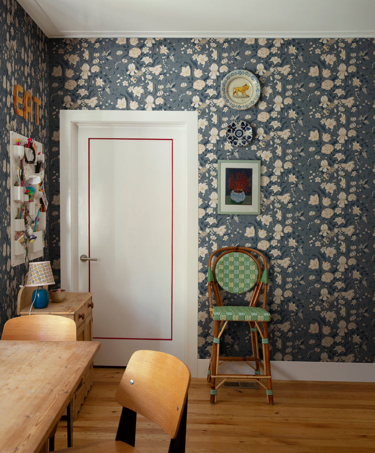 Karins Bukett, Floral Pattern Wallpaper in dark blue featured on a wall of a room with wooden furnitures and flooring.