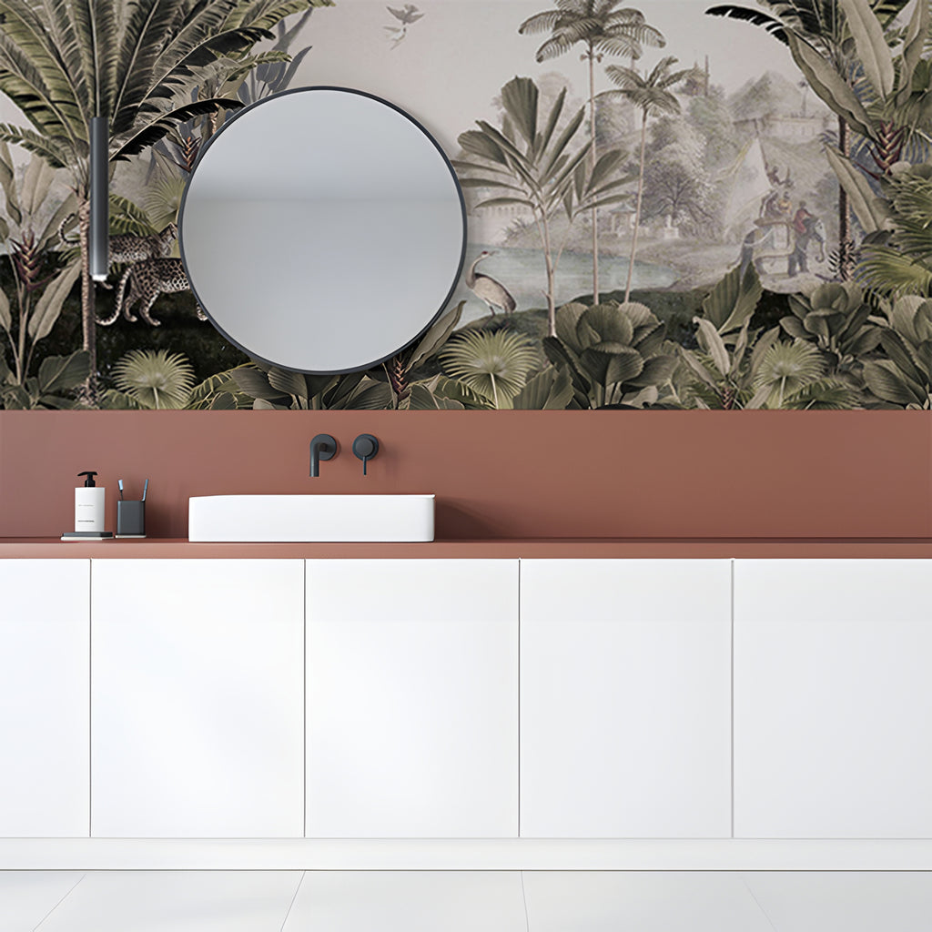 A modern bathroom adorned with a Leopard Landscape, Animal Mural Wallpaper in Sepia. The room features a sleek white vanity unit, a terracotta backsplash, a round mirror, and minimalist black fixtures against a vintage looking wallpaper featuring leopard in the wild