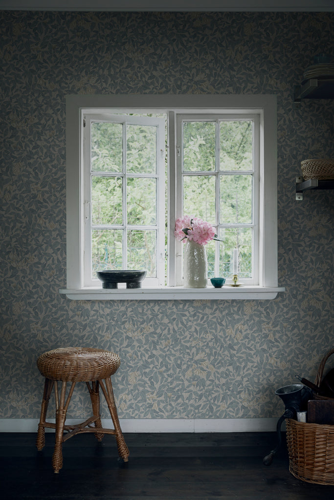 Linnea, Floral Pattern Wallpaper in blue featured on a wall of a room with window and a stool