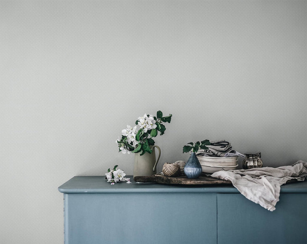 Lisabet, Patterned Wallpaper in blue featured on a wall of a room with a cabinet with vase and and cloth on top